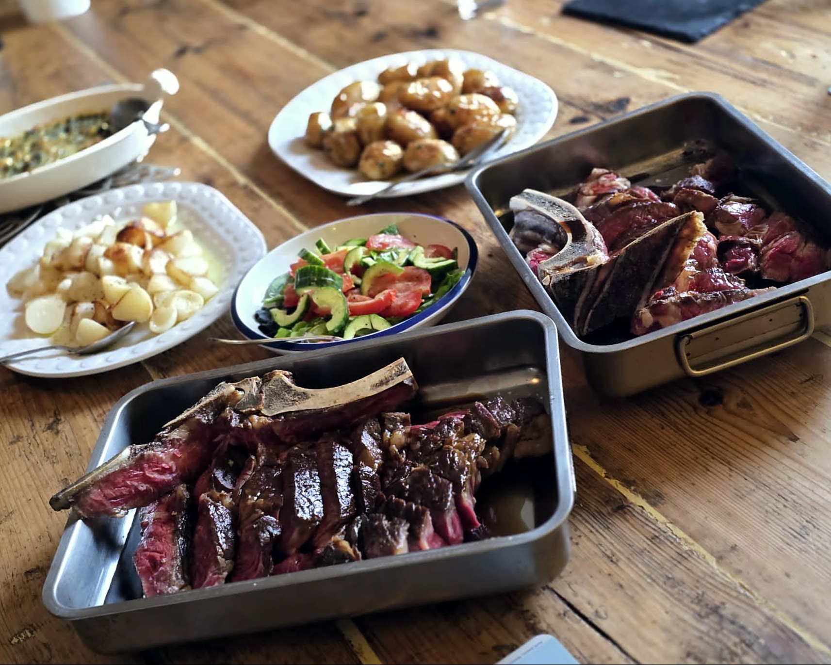 a sharing table of roast beef and dishes