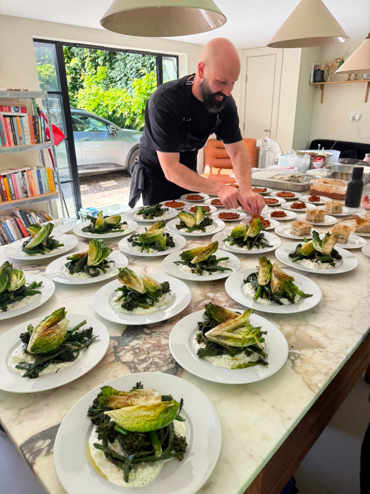 james plating charred hispi cabbage and greens for a private dinner